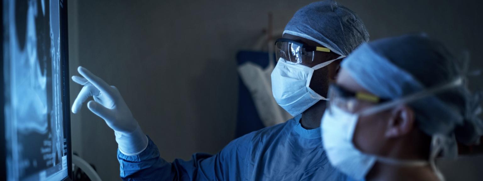 surgeons looking at X-ray board